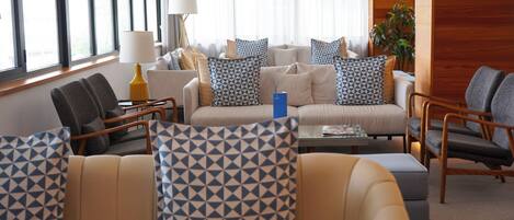 Une chambre d’hôtel moderne, dotée d’un canapé, de fauteuils et d’une table basse.