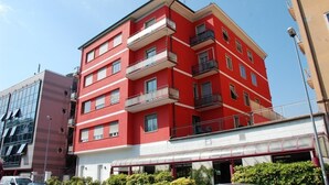 A multi-story red building with balconies and a glass facade. - Piccolo Verona (Verona)
