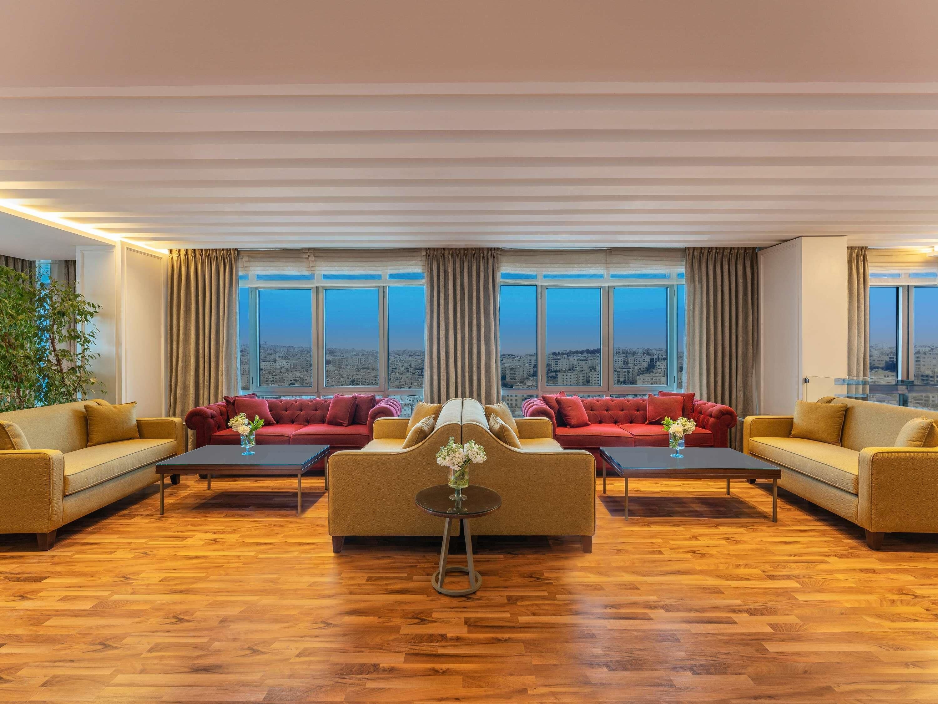 A spacious living room with a city view, two sofas, a coffee table, and a large window.