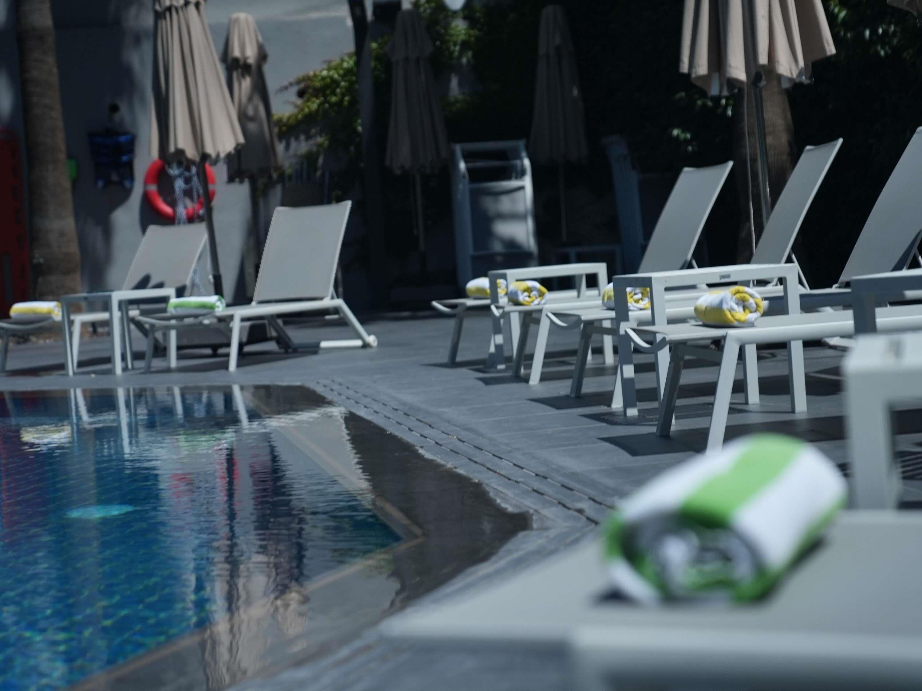 Una piscina al aire libre de temporada, sombrillas