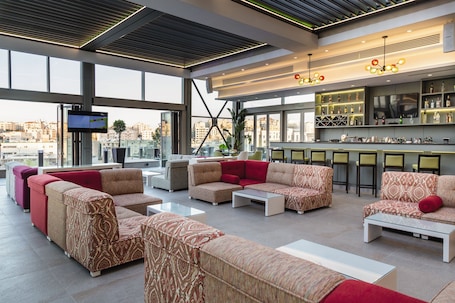 A modern lounge area with sofas and a bar.