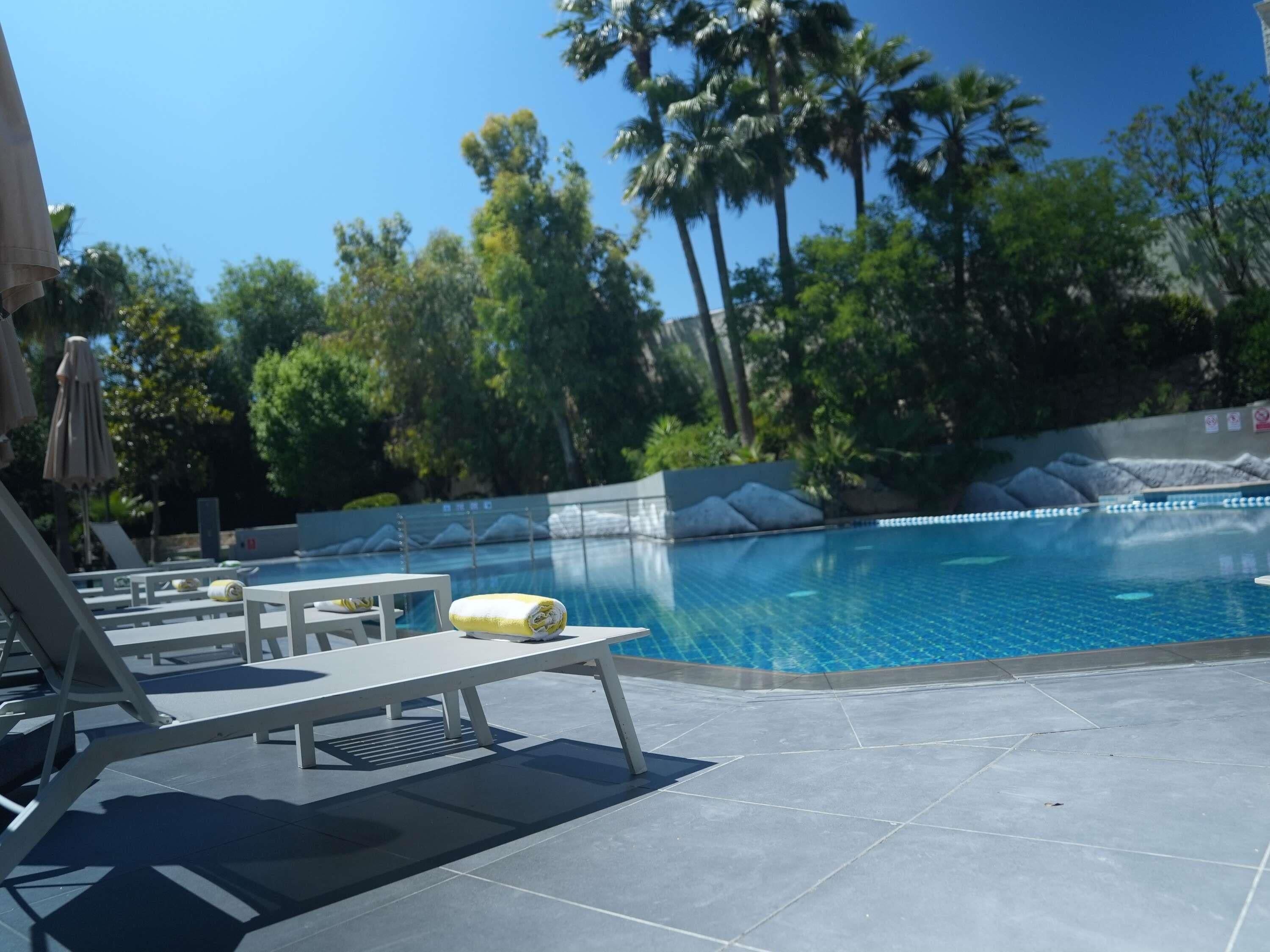 Una piscina al aire libre de temporada, sombrillas