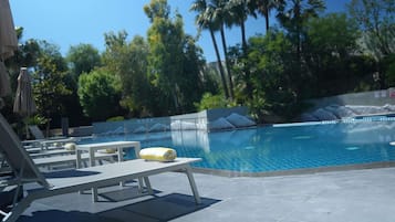 Una piscina al aire libre de temporada, sombrillas