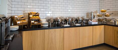A modern kitchen with a central island, equipped with various appliances and food items.