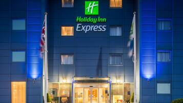 Welcome to Holiday Inn Express, featuring a modern exterior with a prominent logo and glass entrance.