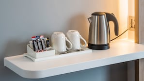 A white shelf with a coffee maker, two white mugs, and a mug holder with Nescafe Original coffee pods. - Holiday Inn Express Oxford-Kassam Stadium by IHG (Oxford)