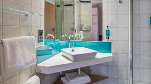 A modern bathroom with a glass-enclosed sink, a mirror, and a shower area. - Holiday Inn Express Oxford-Kassam Stadium by IHG (Oxford)
