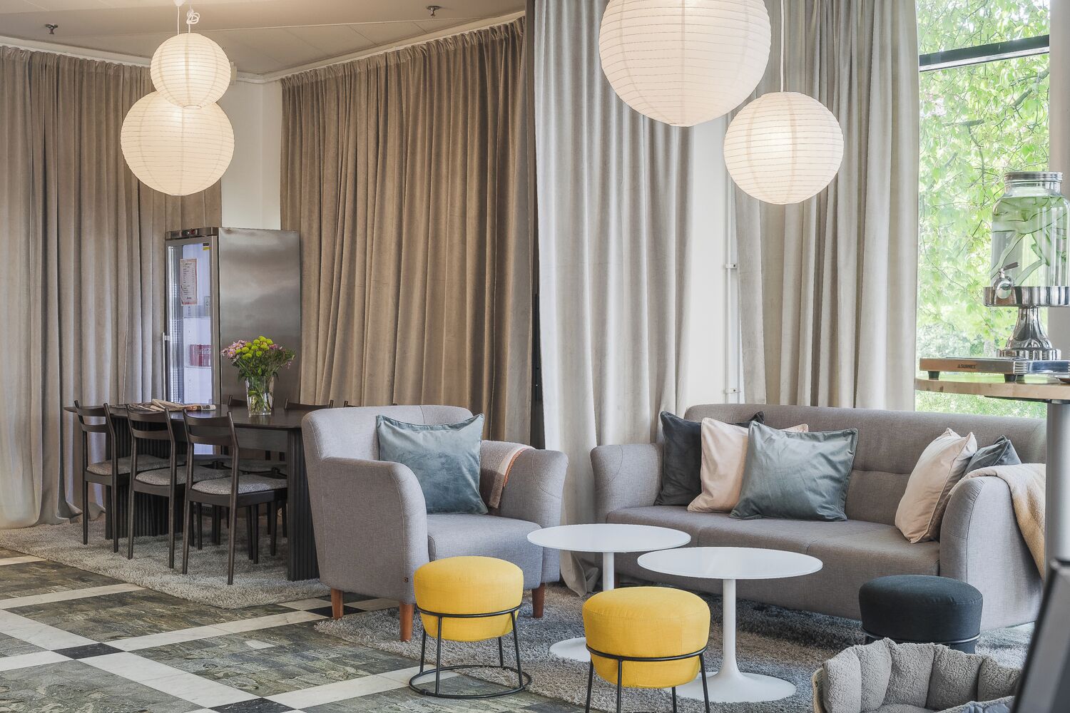 A modern living room with a sofa, armchairs, a dining table, and a coffee table.
