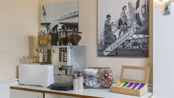 Una estación de café con una máquina de café, tazas y una exhibición de granos de café.