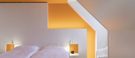 Une chambre à coucher moderne avec un lit, des tables de chevet et une chaise.