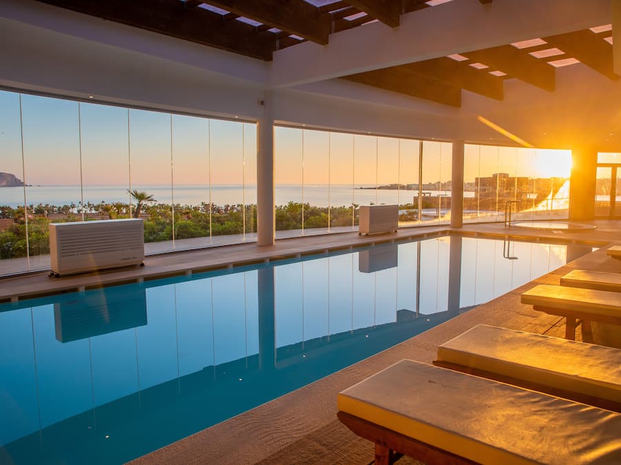 A pool with a view of the ocean and a sunset.