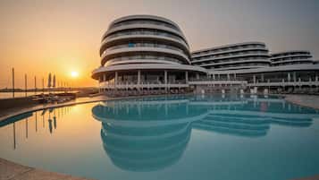 Un hotel moderno con una piscina circular y varios balcones.