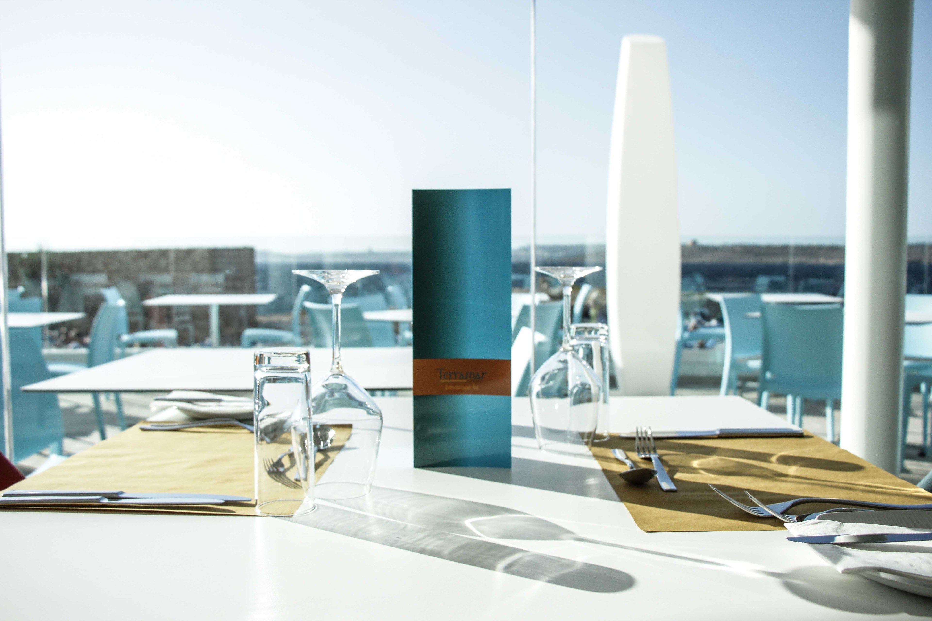 A table set for dining with clear glassware and a menu stand.