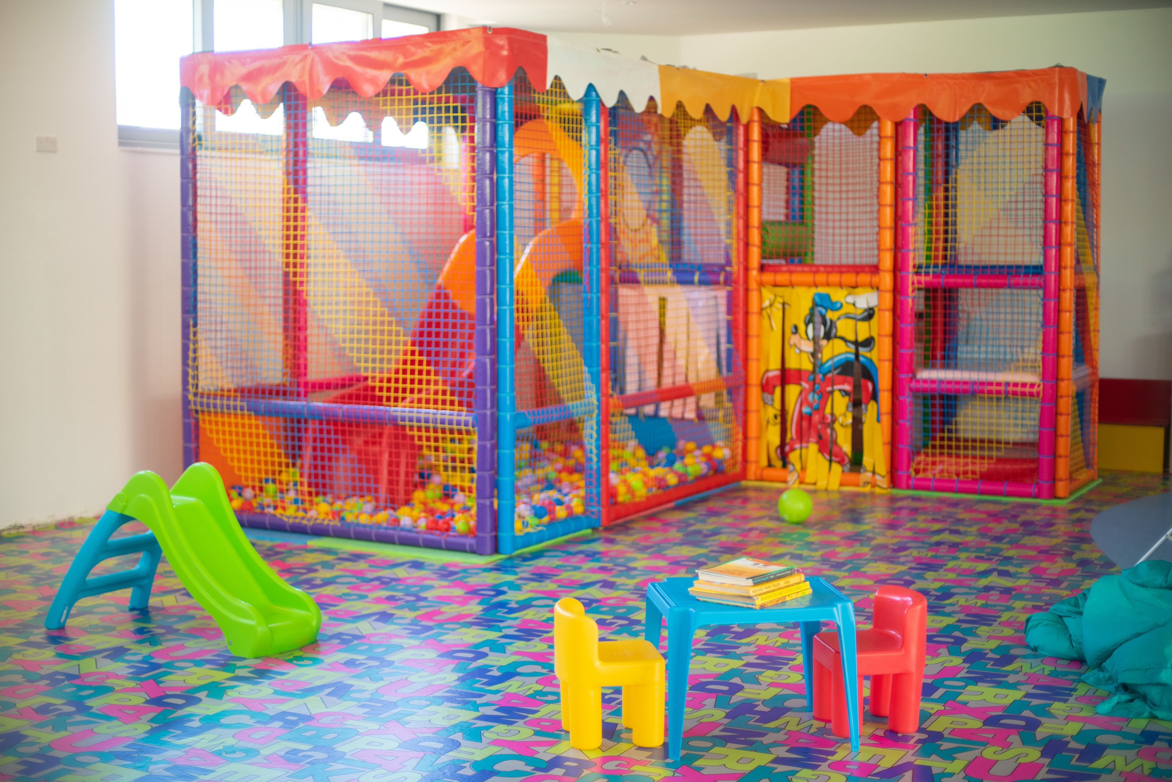 A play area with colorful play structures and a patterned floor.