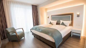 Une chambre d’hôtel moderne avec un grand lit, une chaise et une table de chevet.