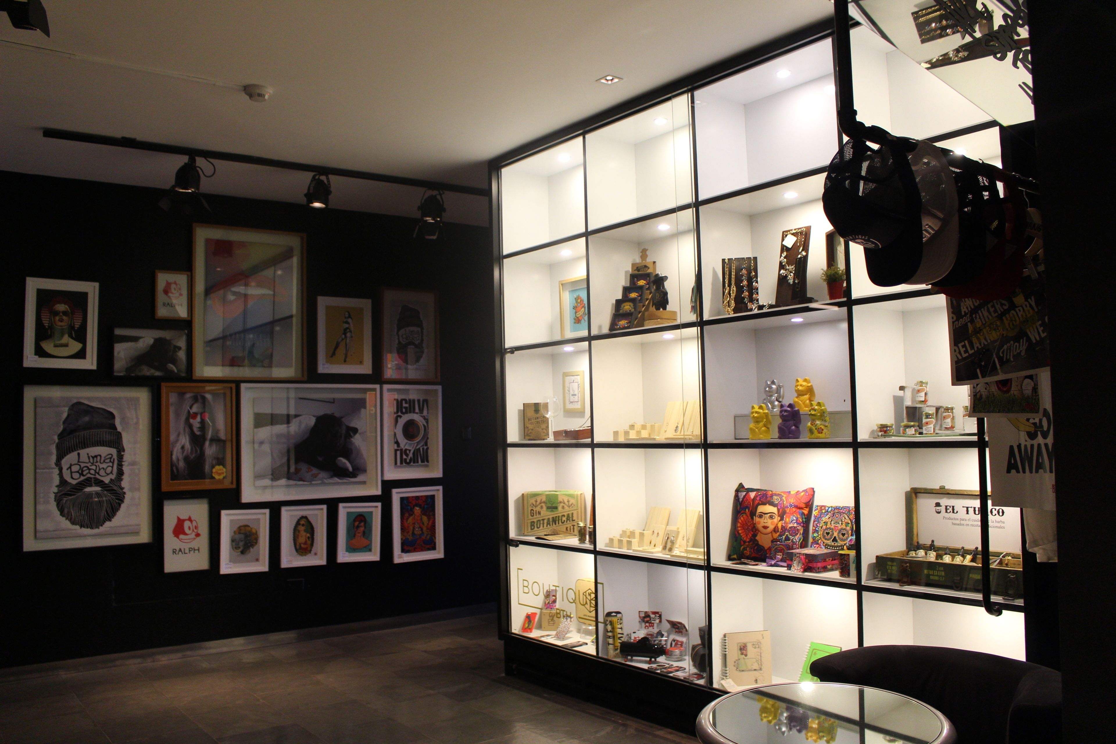 Une galerie où les œuvres d’art sont exposées dans des cadres aux murs, et où des étagères présentent divers objets.