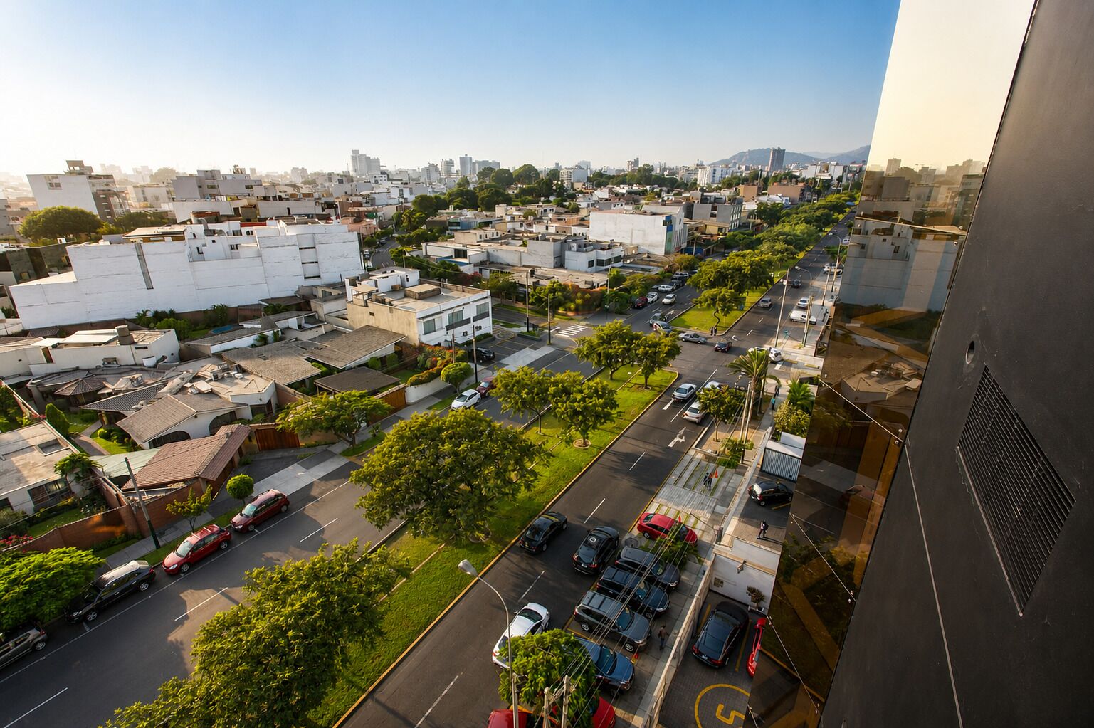 Vista aérea de una zona residencial con edificios, carreteras y vehículos.
