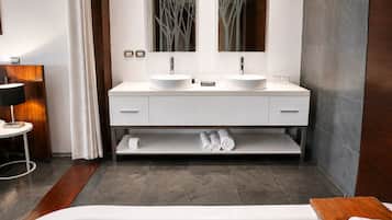 A modern bathroom with a double sink vanity, a bathtub, and a mirror above the sinks.