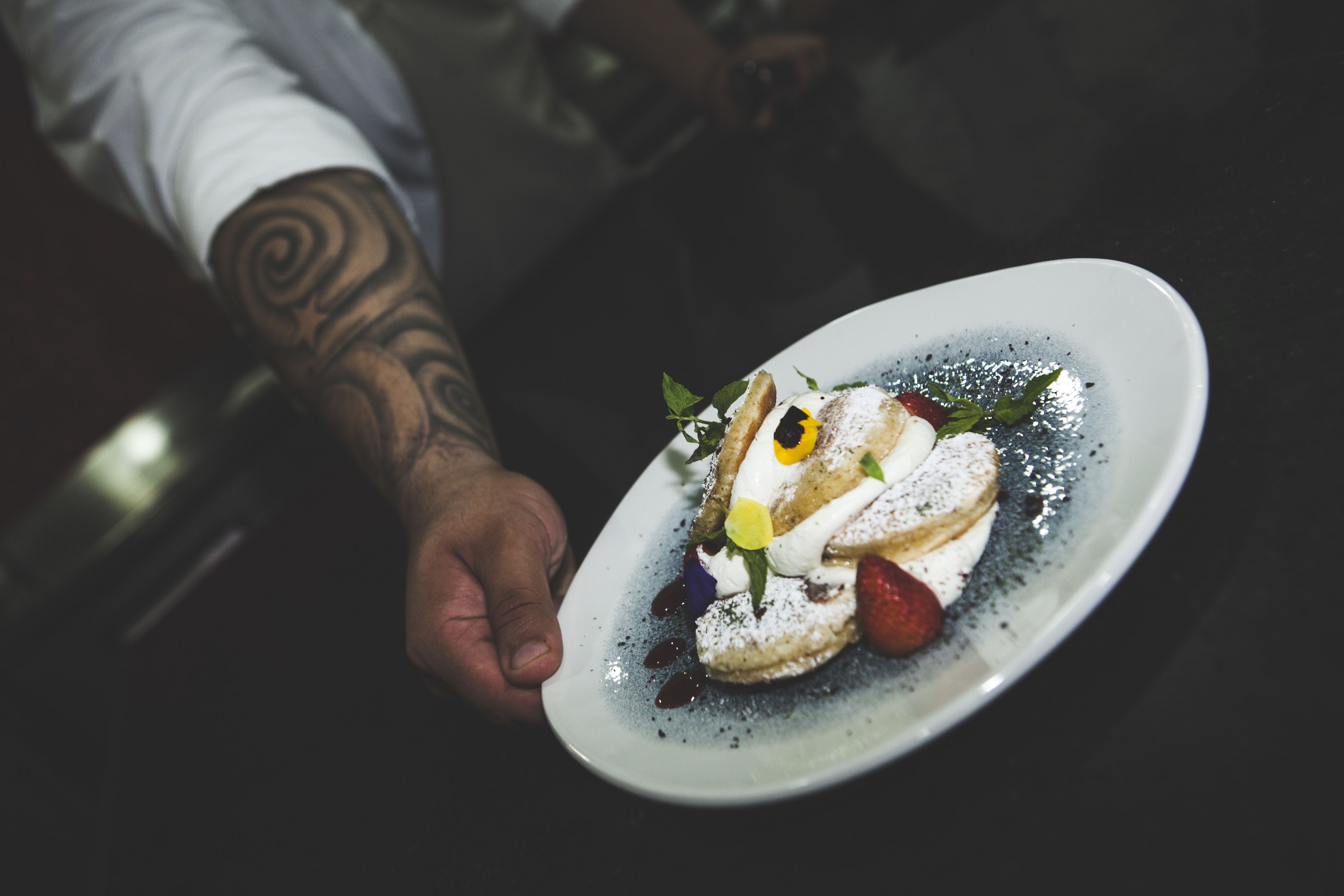A person holding a plate with a dessert.
