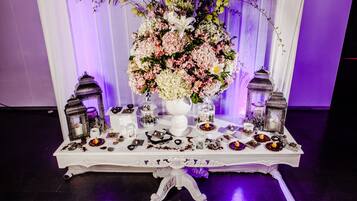 A table with a floral centerpiece, lanterns, and various small decorative items.