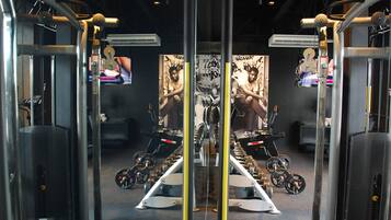 Un gimnasio con equipamiento de ejercicio, cintas de correr y máquinas de pesas.