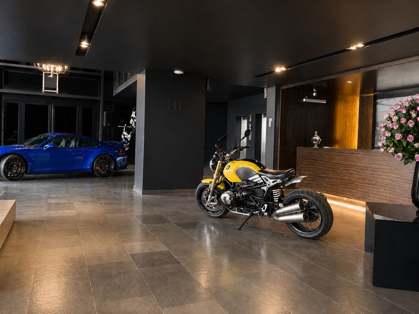 Un espacio de exhibición con una motocicleta BMW y un coche deportivo azul.