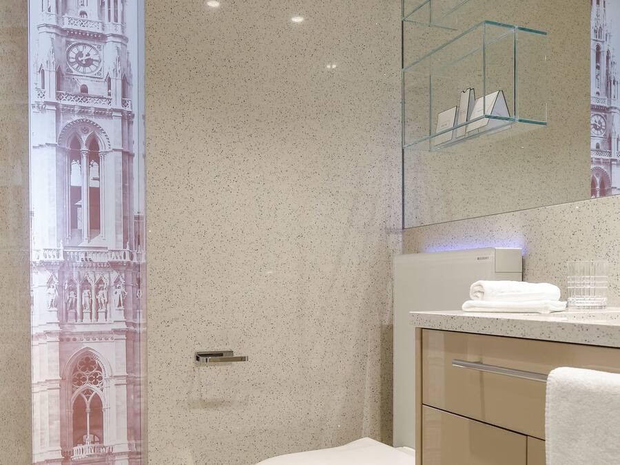 Une salle de bain moderne avec des toilettes sur pied, une étagère en verre au-dessus du lavabo et un grand miroir.