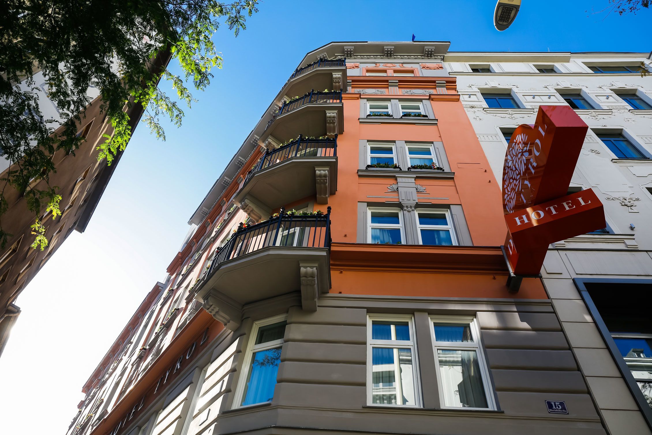 Ein mehrstöckiges Hotel mit einem auffälligen, roten Schild, das den Namen des Hotels anzeigt.