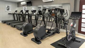 Ein Fitnessstudio mit Laufbändern, Crosstrainern und Ergometer.