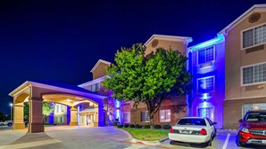 A hotel entrance with a covered driveway, a tree, and two parked cars. - Best Western Plus Cutting Horse Inn & Suites (Weatherford)