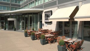 A hotel exterior with outdoor seating and a modern design. - NH Frankfurt Niederrad (Frankfurt)