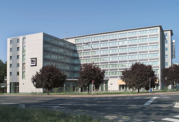 Hotel features a modern glass facade and a multi-storied design.