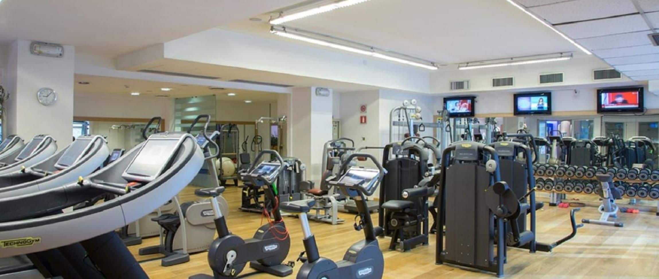 A gym with treadmills, weight machines, and exercise balls.