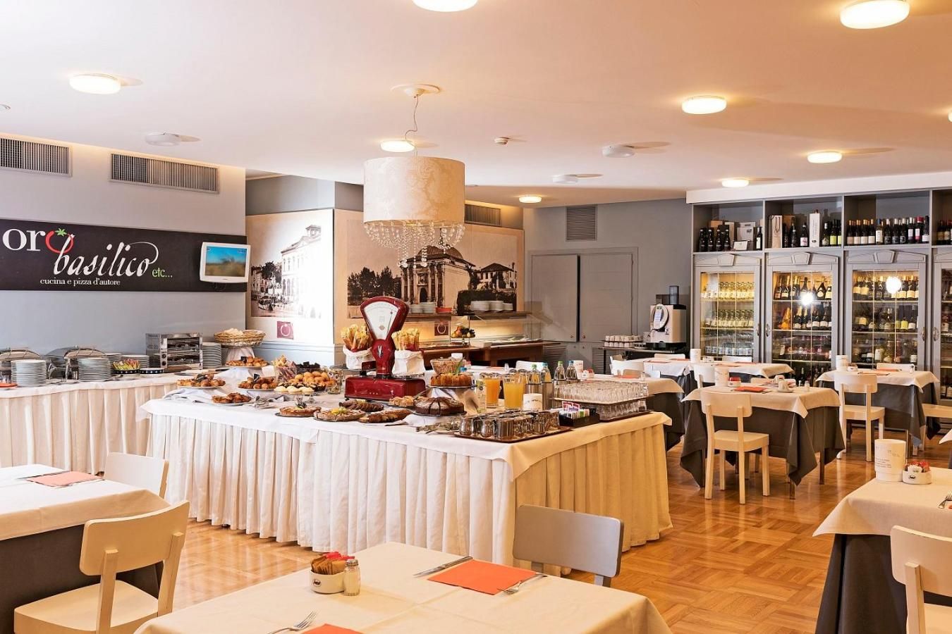 Un restaurante con una barra de buffet, una máquina de café y una exhibición de vinos.
