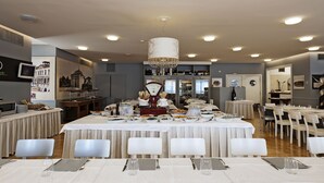 A dining area with multiple tables set for service, a chandelier, and a wine refrigerator in the background. - Hotel Maggior Consiglio (Treviso)