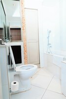 A modern bathroom with a toilet, a shower, and a sink.