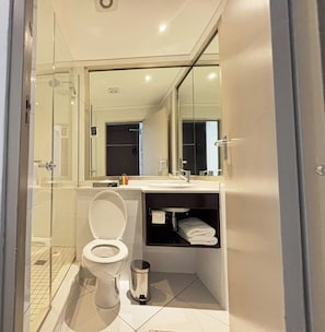 Une salle de bain moderne équipée de toilettes, d’un lavabo et d’une zone douche.