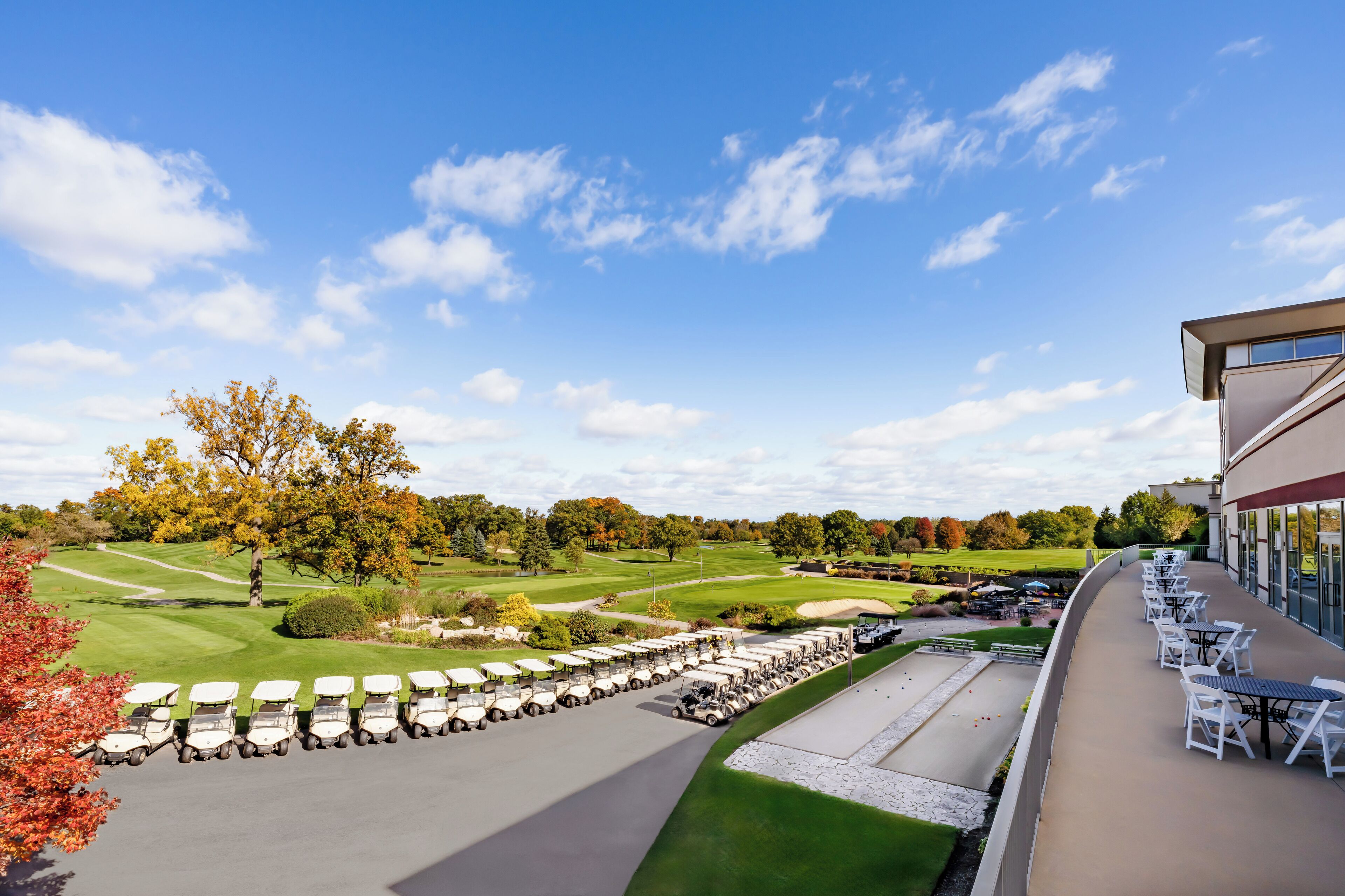 Un campo de golf con club house y zona de estar al aire libre.