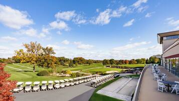 Un campo de golf con club house y zona de estar al aire libre.