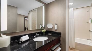 Un baño moderno con un espejo grande, un lavabo y una ducha.