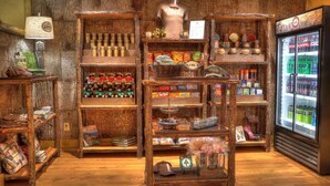 Une boutique au décor rustique, avec des étagères en bois où sont exposés des en-cas, des boissons et des souvenirs.
