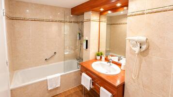 Un baño moderno con bañera, lavamanos y espejo.