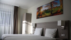A hotel room with a large bed, two bedside tables, a nightstand, and a painting on the wall. - Fletcher Hotel De Geulvallei (Valkenburg aan de Geul)