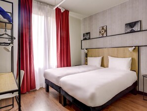 A hotel room with two beds, a desk, a chair, a phone, and a window with curtains. - ibis Daumesnil Porte Dorée (Paris)
