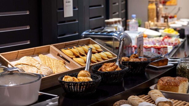 Un buffet proposant une variété de produits de boulangerie, notamment des pâtisseries et du pain, disposés sur un comptoir.