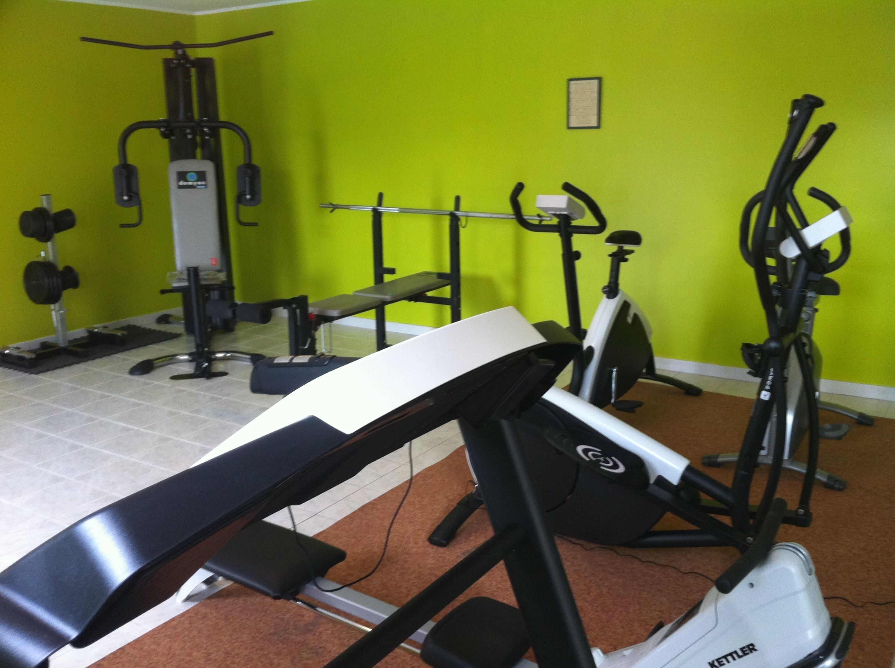 A gym with exercise equipment including a treadmill, stationary bike, and weight machines.