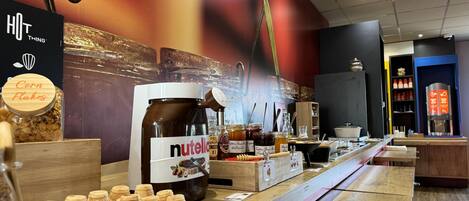 Una presentación de Nutella con botes y un bote grande de copos de maíz.