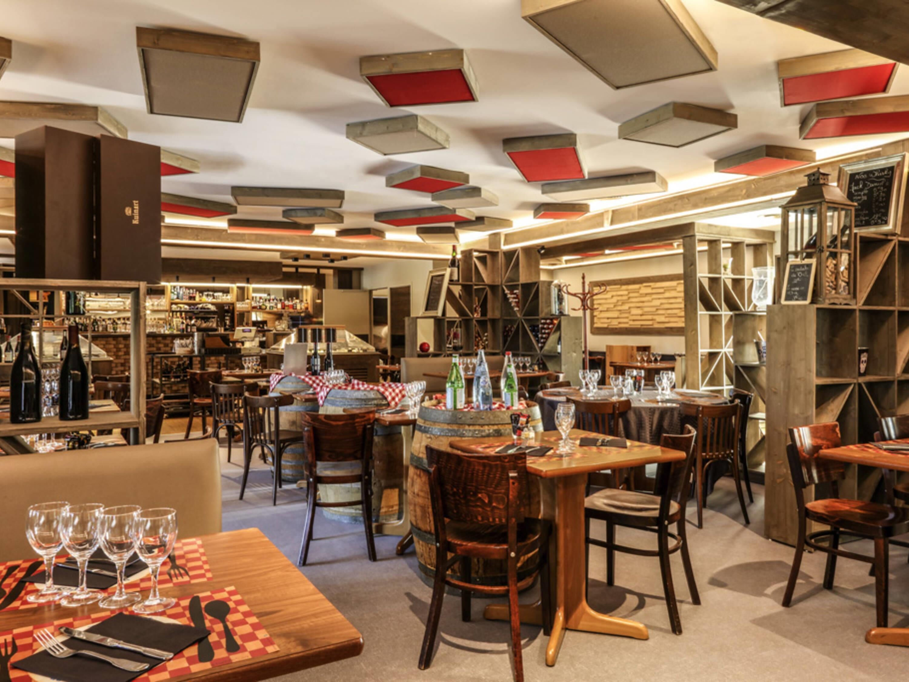A restaurant interior with tables, chairs, and a bar area.
