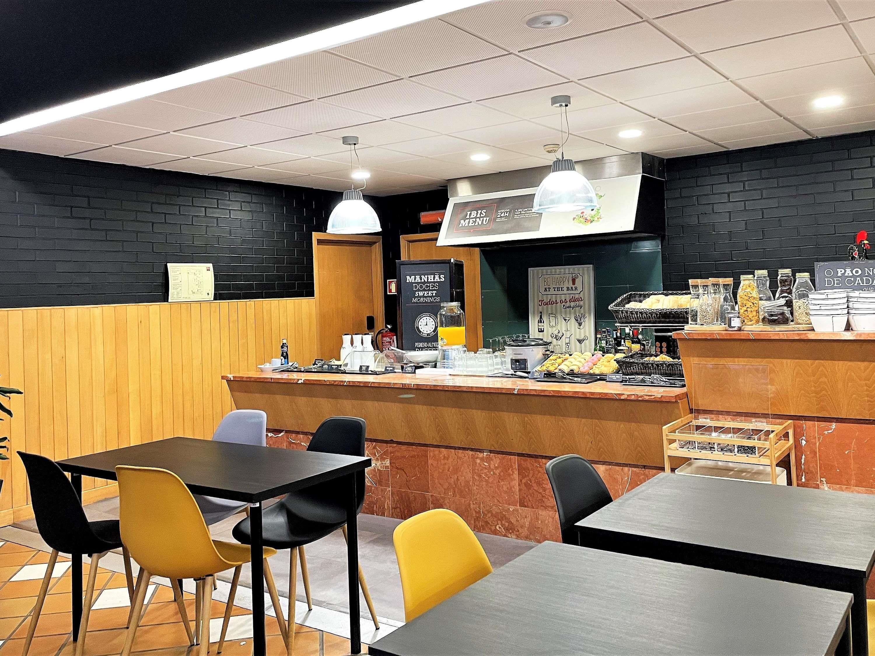 A cafe with a counter, chairs, and a menu board.