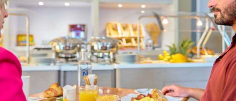 A breakfast setting with a table, plates of food, and a beverage.
